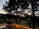 Back deck with outdoor lighting, lounge chairs, and views of trees at dusk at 5 Catamount Ln, Littleton, CO 80127
