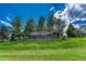 Backyard view with lush green lawn and mature trees, enhancing the property's outdoor appeal at 5 Catamount Ln, Littleton, CO 80127