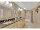 Bathroom featuring dual sinks, granite counters, and a tiled shower at 5 Catamount Ln, Littleton, CO 80127