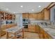 Eat-in kitchen featuring custom wood cabinets, an island, and modern appliances at 5 Catamount Ln, Littleton, CO 80127