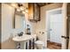 Elegant bathroom with a pedestal sink, modern toilet, wooden ceiling, and rustic-chic design at 1941 Boreas Pass Rd # 1C, Breckenridge, CO 80424