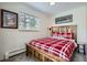 Comfortable bedroom with a wooden bed frame, red plaid bedding, and a window with natural light at 1941 Boreas Pass Rd # 1C, Breckenridge, CO 80424