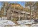 Three-story exterior featuring multiple balconies surrounded by trees and snow-covered ground at 1941 Boreas Pass Rd # 1C, Breckenridge, CO 80424