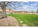 Expansive backyard featuring a lush green lawn, mature trees, and a stone path, perfect for outdoor enjoyment at 490 Potomac Way, Aurora, CO 80012