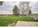 Large, green backyard with mature trees and a fence providing privacy and space for outdoor activities and relaxation at 490 Potomac Way, Aurora, CO 80012