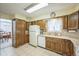 Functional kitchen featuring ample oak cabinetry, tiled floors, and modern appliances, perfect for culinary enthusiasts at 490 Potomac Way, Aurora, CO 80012