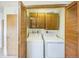 Convenient laundry area with washer, dryer, and storage cabinets with louvered closet doors at 490 Potomac Way, Aurora, CO 80012