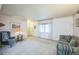 Inviting living room features neutral carpet, a bright window, and comfortable seating, offering a relaxing atmosphere at 490 Potomac Way, Aurora, CO 80012