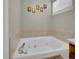 A bright bathroom features a soaking tub with tile surround and framed wall art at 1234 Riddlewood Ln, Highlands Ranch, CO 80129