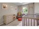 Inviting Bedroom featuring a cozy chair, soft rug, dresser and a crib by a bright window at 1234 Riddlewood Ln, Highlands Ranch, CO 80129