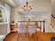 A dining room with hardwood floors and decorative chandelier open to a living space at 1234 Riddlewood Ln, Highlands Ranch, CO 80129