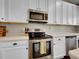 Close-up of the sleek stainless steel oven and microwave, surrounded by crisp white cabinetry at 1234 Riddlewood Ln, Highlands Ranch, CO 80129