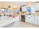 Bright kitchen featuring tile floors, white cabinets, and a view into the dining area and deck at 846 E 114Th Pl, Northglenn, CO 80233