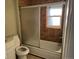 Bathroom featuring shower-tub combination with glass sliding door and window at 1285 N Colorado Blvd # 4, Denver, CO 80206