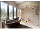Spa-like bathroom with freestanding tub, glass-enclosed shower, and natural light at 9 Polo Field Ln, Denver, CO 80209