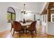 Elegant dining room featuring unique chandelier, tile flooring, and arched window for ample natural light at 9 Polo Field Ln, Denver, CO 80209