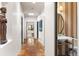 Hallway with terra cotta flooring leading to a powder room with bronze fixtures at 9 Polo Field Ln, Denver, CO 80209