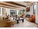 Spacious living room with wooden beamed ceilings, a fireplace, and comfortable seating arrangements at 9 Polo Field Ln, Denver, CO 80209