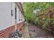Side yard with a narrow walkway and mature landscaping create privacy at 4072 Ames St, Wheat Ridge, CO 80212