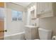 Bathroom with a vanity, a tiled tub/shower, toilet and updated features for modern living at 4072 Ames St, Wheat Ridge, CO 80212