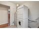 Functional laundry area with stacked washer/dryer, water heater and laminate flooring at 4072 Ames St, Wheat Ridge, CO 80212