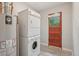 Laundry room with washer/dryer stack, water heater and access door at 4072 Ames St, Wheat Ridge, CO 80212