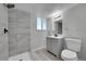 This bathroom has a modern vanity, toilet and tiled shower with a glass door and a window at 3164 Scranton St, Aurora, CO 80011