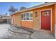 Close up of a charming orange brick home with a bright red front door at 3164 Scranton St, Aurora, CO 80011