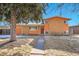Charming orange brick home with mature tree, featuring a red front door and walkway at 3164 Scranton St, Aurora, CO 80011