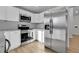 Modern kitchen with stainless steel refrigerator and appliances, white cabinetry, granite countertop and subway tile backsplash at 3164 Scranton St, Aurora, CO 80011