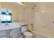Bright bathroom with a shower-tub combo, single sink vanity, and large mirror at 8751 Pearl St # D1, Thornton, CO 80229