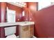 Bathroom featuring a vanity, toilet, mirror, and unique red wall color at 8751 Pearl St # D1, Thornton, CO 80229