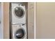 Convenient laundry area with a stacked washer and dryer unit and a white door at 8751 Pearl St # D1, Thornton, CO 80229