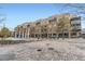Multi-story building exterior with brick facade, balconies, and courtyard with decorative art at 7220 W Bonfils Ln # 206, Lakewood, CO 80226