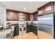 Modern kitchen featuring granite counters, updated appliances, and a refrigerator at 7220 W Bonfils Ln # 206, Lakewood, CO 80226