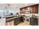 Well-equipped kitchen with dark wood cabinets, stainless steel appliances, and granite countertops at 7220 W Bonfils Ln # 206, Lakewood, CO 80226