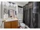 Bathroom features a single sink vanity, shower with dark curtain, and storage above the toilet at 13884 Lilac St, Thornton, CO 80602