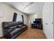 Living room features a ceiling fan, dark wood media center, and a dark leather sofa at 13884 Lilac St, Thornton, CO 80602