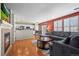 Open-concept living room featuring a fireplace, hardwood floors, and seamless access to the modern kitchen at 13884 Lilac St, Thornton, CO 80602