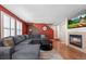 Comfortable living room with a cozy fireplace, hardwood floors, and bright windows with shutter blinds at 13884 Lilac St, Thornton, CO 80602
