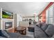 Open-concept living room featuring a fireplace, hardwood floors, and seamless access to the modern kitchen at 13884 Lilac St, Thornton, CO 80602