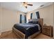 Relaxing main bedroom features a ceiling fan, and a comfortable wood framed bed with dark bedding at 13884 Lilac St, Thornton, CO 80602