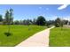 Scenic park view with a paved pathway, grassy fields, and mature trees, perfect for recreation and relaxation at 13884 Lilac St, Thornton, CO 80602