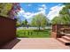 Backyard view from a deck, showcasing lush lawn and a tennis court at 6213 S Galena Way, Englewood, CO 80111