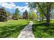 Landscaped community lawn and path surrounded by mature trees at 6213 S Galena Way, Englewood, CO 80111