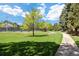 Lush community lawn featuring mature trees and a winding walking path at 6213 S Galena Way, Englewood, CO 80111