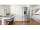 Stylish kitchen with stainless steel refrigerator, breakfast bar, and hardwood floors at 6213 S Galena Way, Englewood, CO 80111