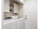 Functional laundry room with washer, dryer, storage cabinets, and access door at 6213 S Galena Way, Englewood, CO 80111