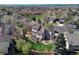 Aerial view of a home with a backyard deck and patio, surrounded by mature trees in a residential neighborhood at 12646 S Dove Creek Way, Parker, CO 80134