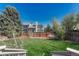 Lush green backyard featuring a lawn surrounded by trees and a wood fence at 12646 S Dove Creek Way, Parker, CO 80134